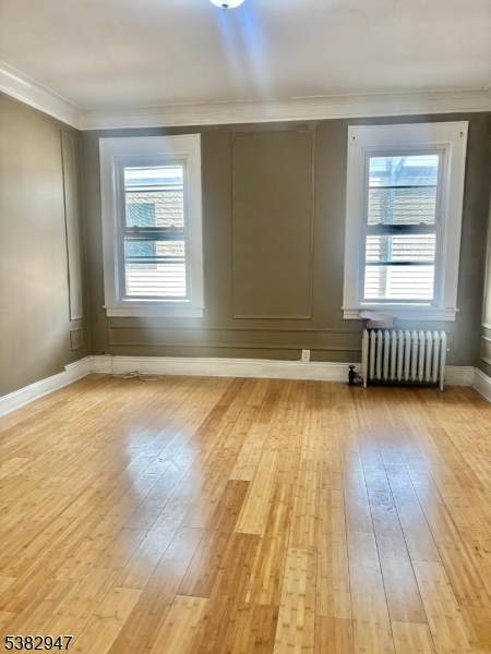 187 Shephard Avenue Newark, NJ 07112 - Photo 3 of 18 an empty room with wooden floor and windows
