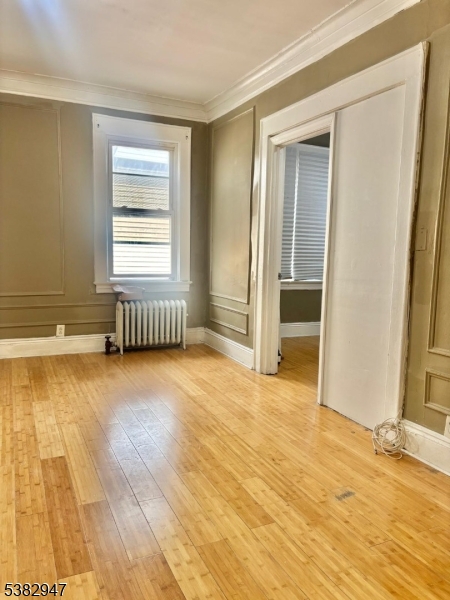 187 Shephard Avenue Newark, NJ 07112 - Photo 5 of 18 an empty room with wooden floor and windows