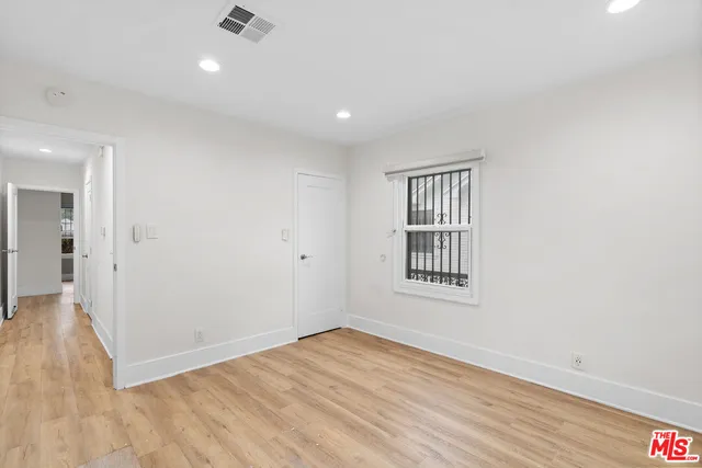 a view of an empty room with wooden floor
