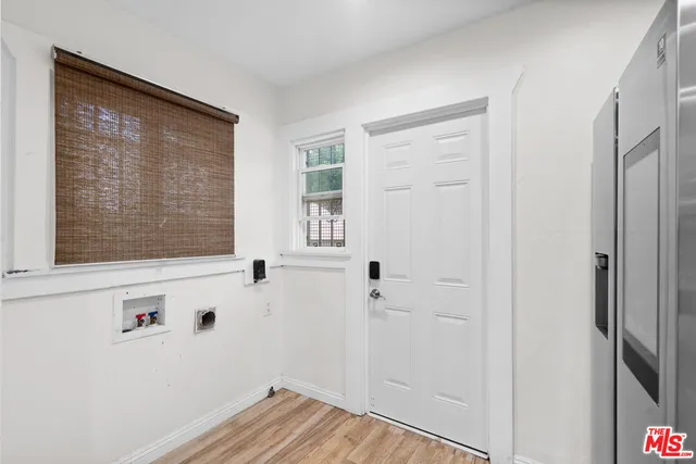 a kitchen with stainless steel appliances a sink dishwasher stove refrigerator and cabinets with wooden floor