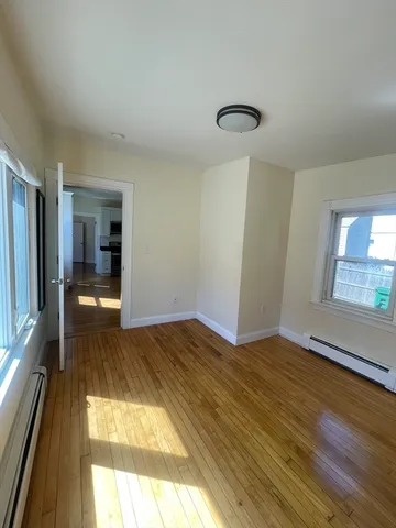 a view of a room with wooden floor and a window