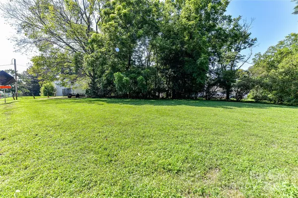a view of a green field with trees in the background