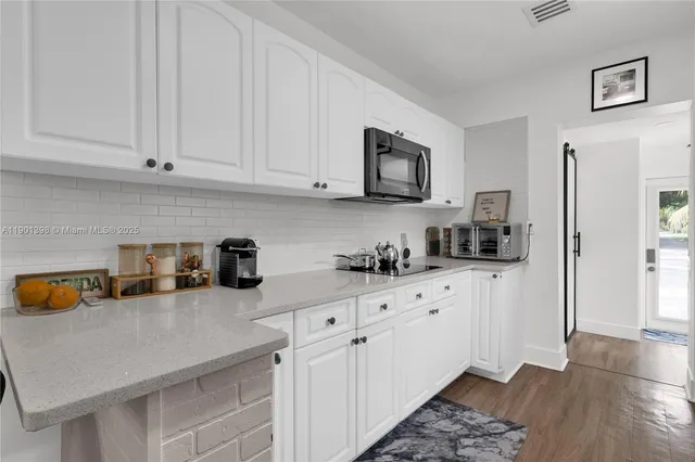 a kitchen with white cabinets and a sink