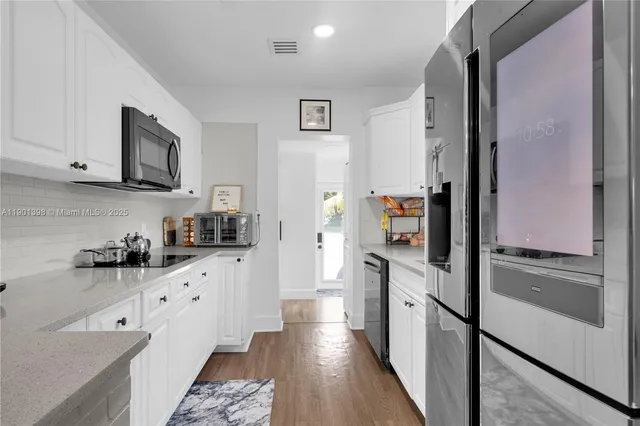 a kitchen with stainless steel appliances a stove refrigerator and cabinets