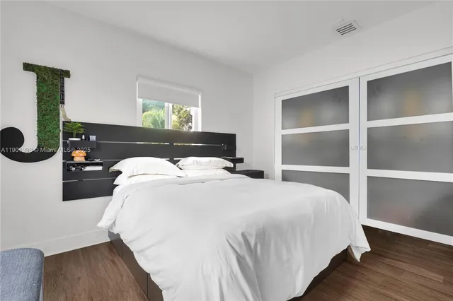 a bedroom with a bed and wooden floor