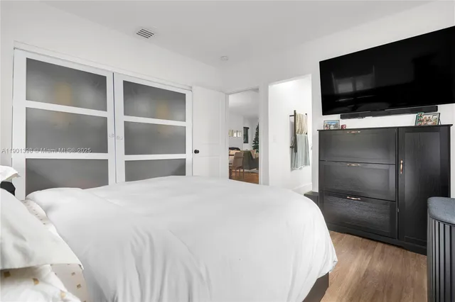 a bedroom with a bed and a flat screen tv