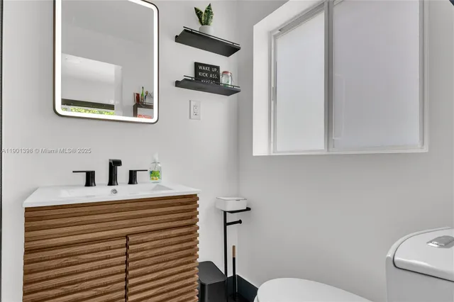 a bathroom with a sink a toilet and mirror