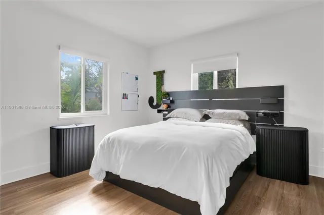 a bedroom with a bed and wooden floor