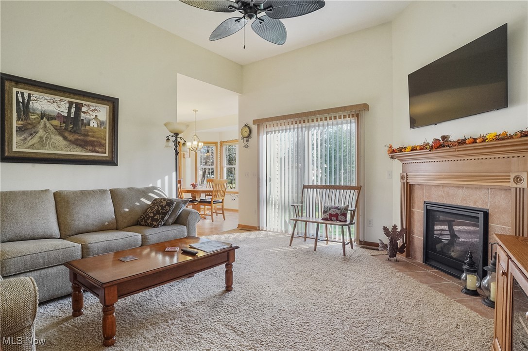 861 Susan Road Ravenna, OH 44266 - Photo 6 of 45 Living room featuring ceiling fan with notable chandelier, light tile patterned floors, and a fireplace