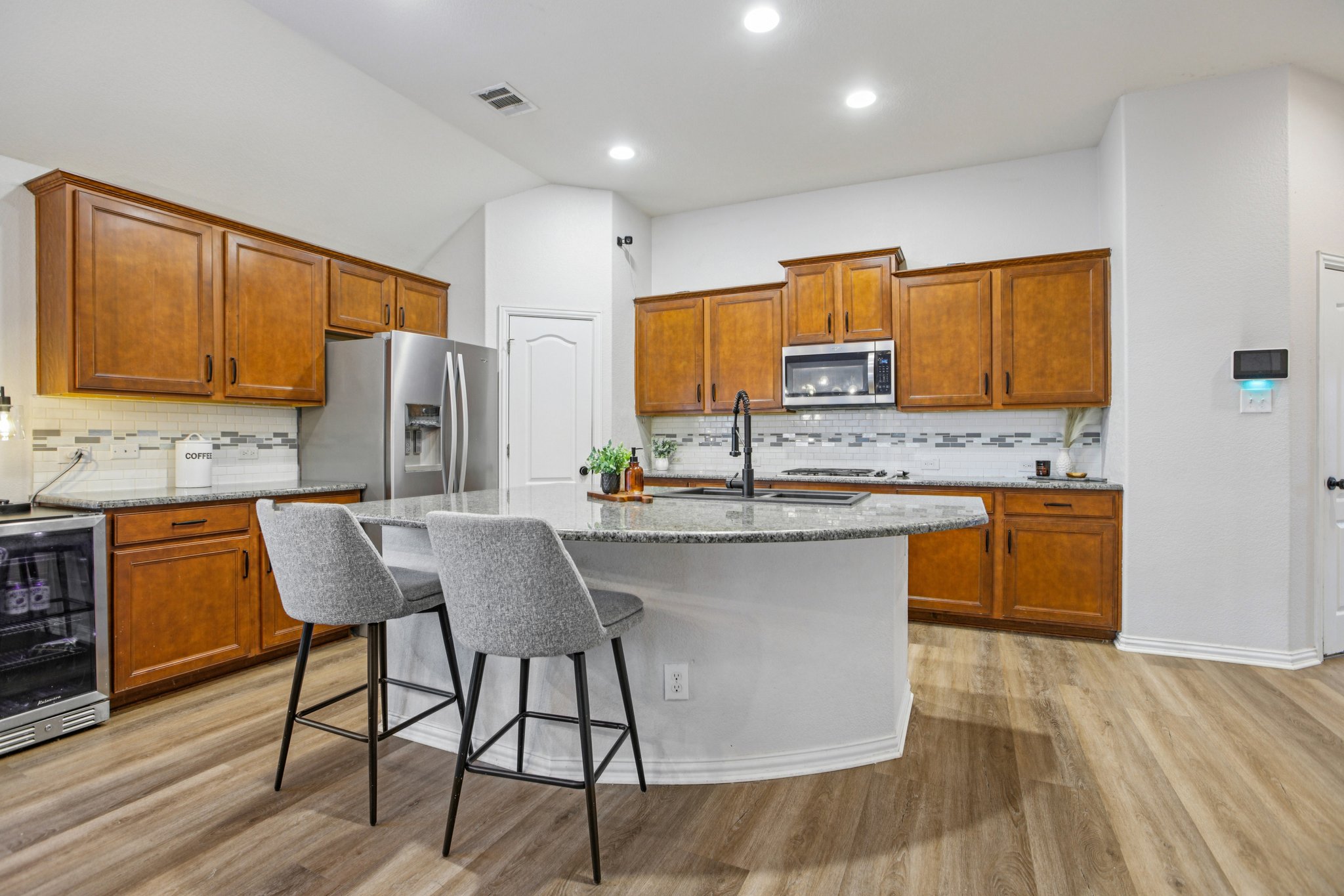 2308 Wind Vane West Pflugerville, TX 78660 - Photo 5 of 28 a kitchen with stainless steel appliances granite countertop a kitchen island hardwood floor sink and stove