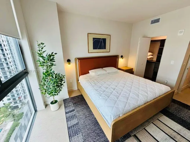 a bed sitting in a bedroom next to a window