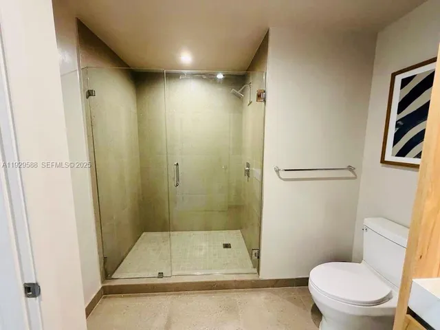 a bathroom with a toilet and a shower
