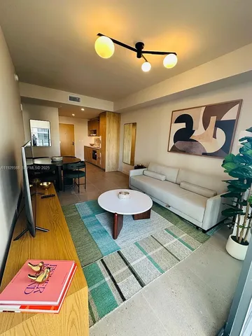 a living room with patio furniture and a wooden floor
