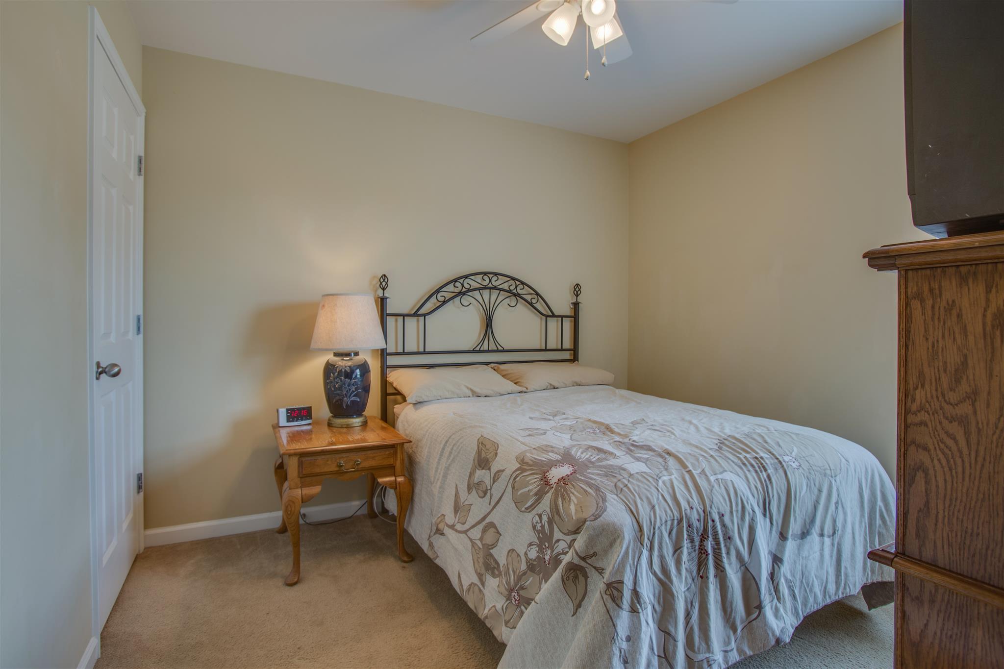 7039 Nickalus Way Spring Hill, TN 37174 - Photo 16 of 21 a bedroom with a bed and a flat tv screen on a dresser