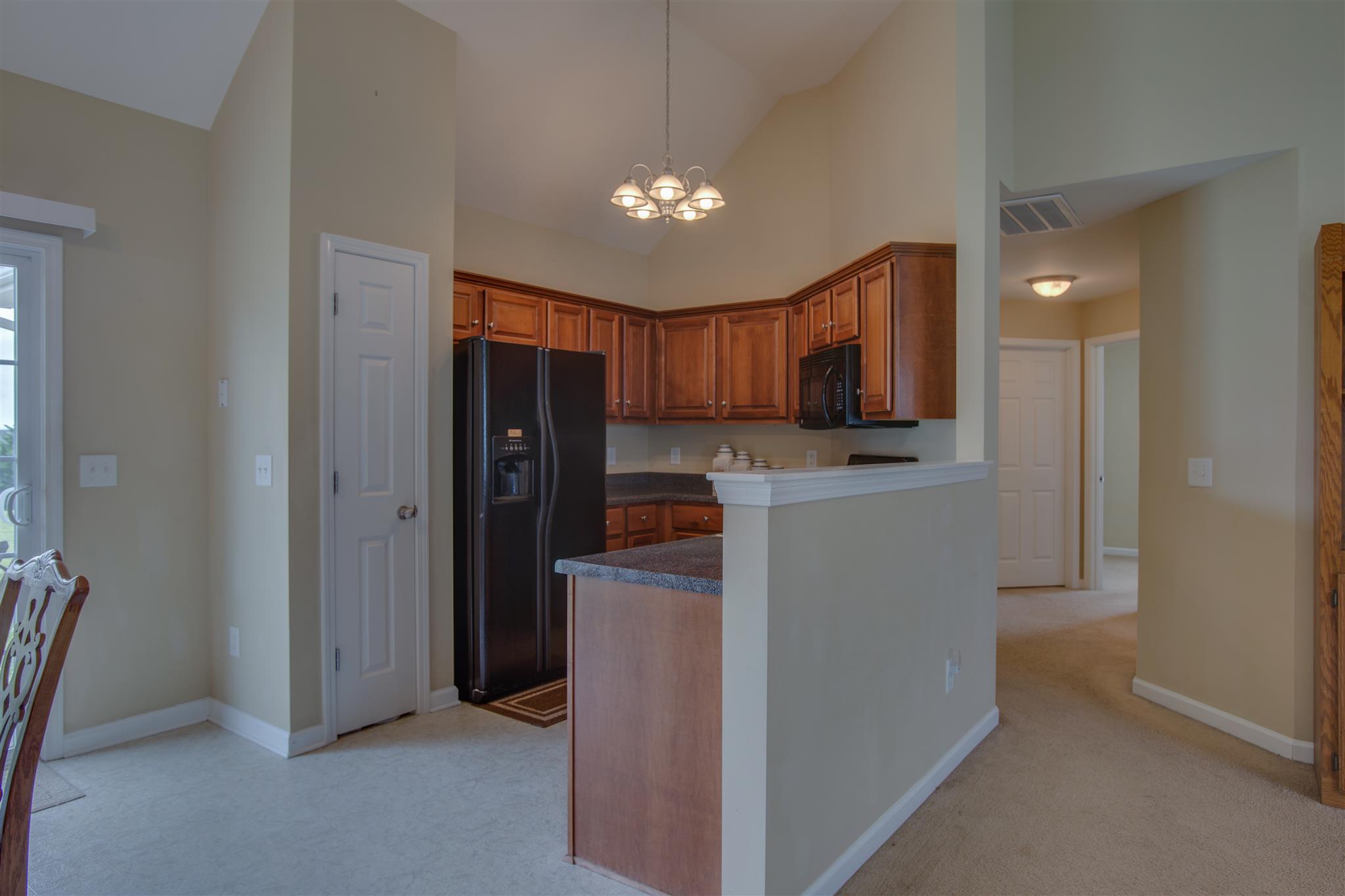 7039 Nickalus Way Spring Hill, TN 37174 - Photo 8 of 21 a view of a kitchen with a sink cabinet and a refrigerator