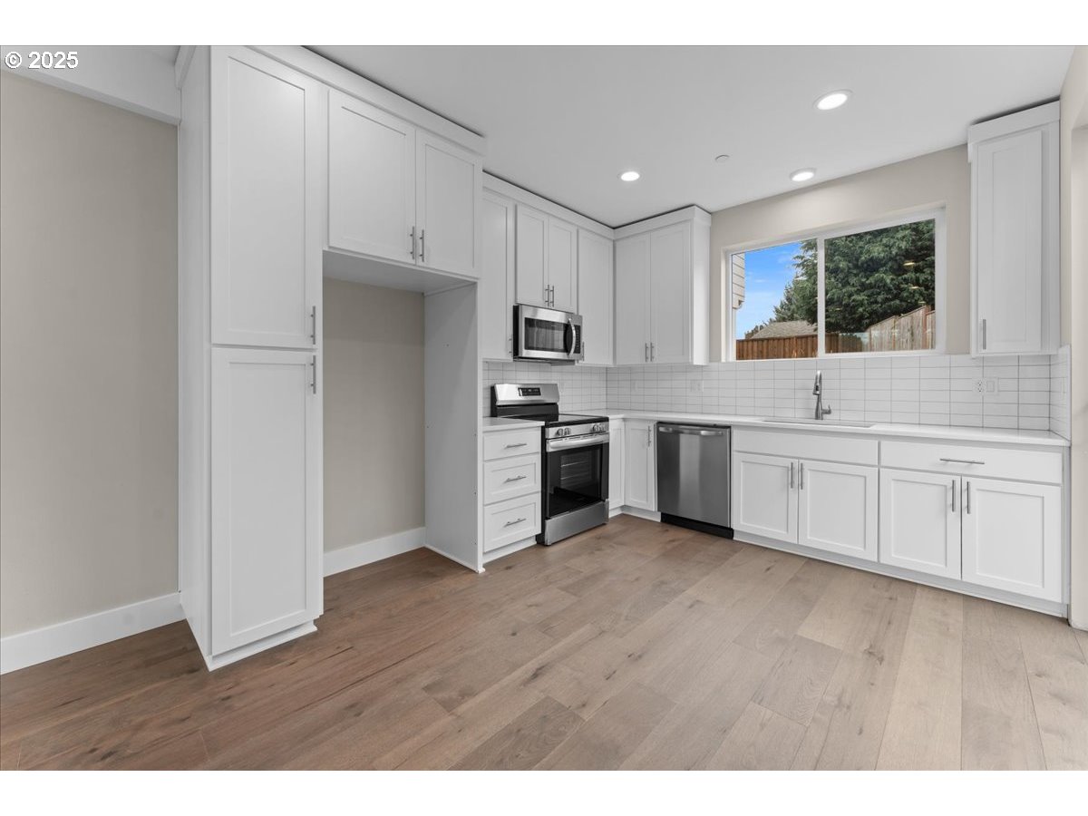 9824 Southwest 34th Place Portland, OR 97219 - Photo 3 of 19 a kitchen with stainless steel appliances granite countertop a stove a sink and a refrigerator