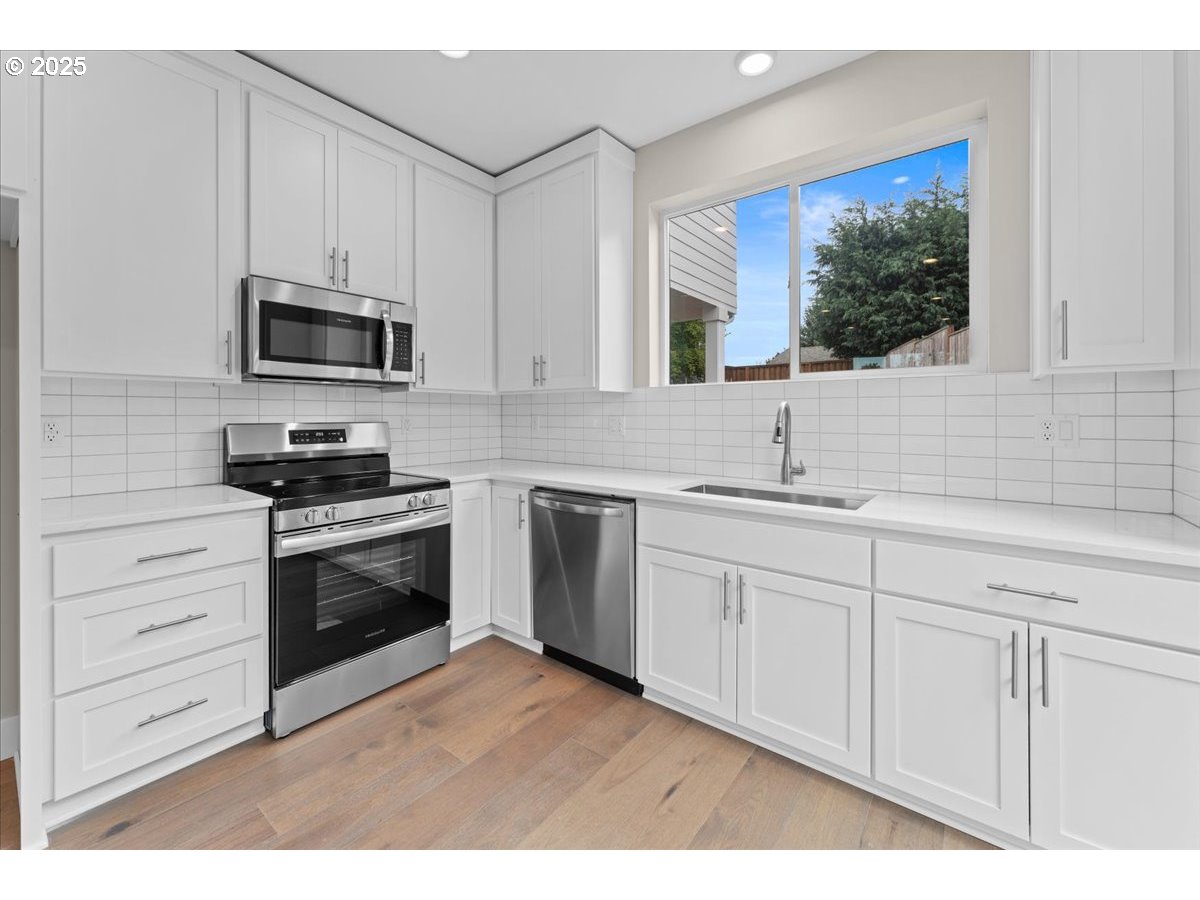 9824 Southwest 34th Place Portland, OR 97219 - Photo 4 of 19 a kitchen with stainless steel appliances granite countertop a sink and a microwave