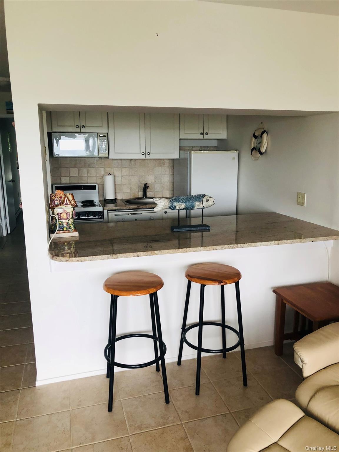 274 Dune Road Westhampton Beach, NY 11978 - Photo 7 of 14 a kitchen with a table chairs stove and cabinets