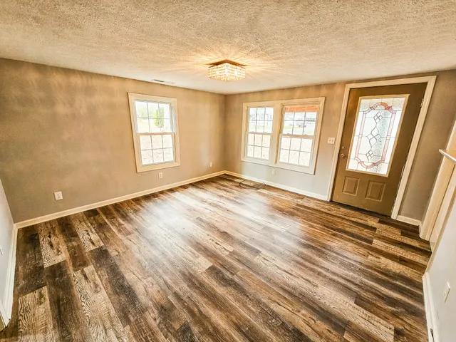 a view of a patio with couches table and chairs with wooden floor and fence