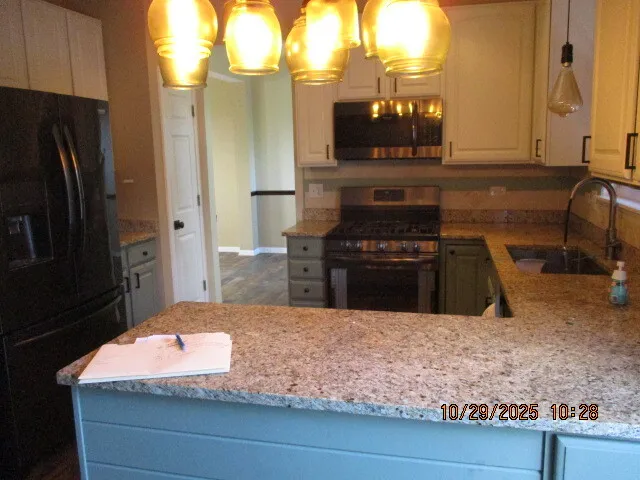 a kitchen with kitchen island granite countertop a refrigerator and a stove