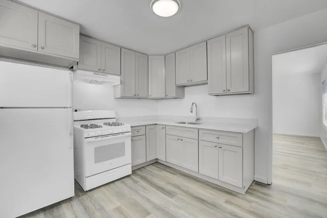 a kitchen with white cabinets and white appliances