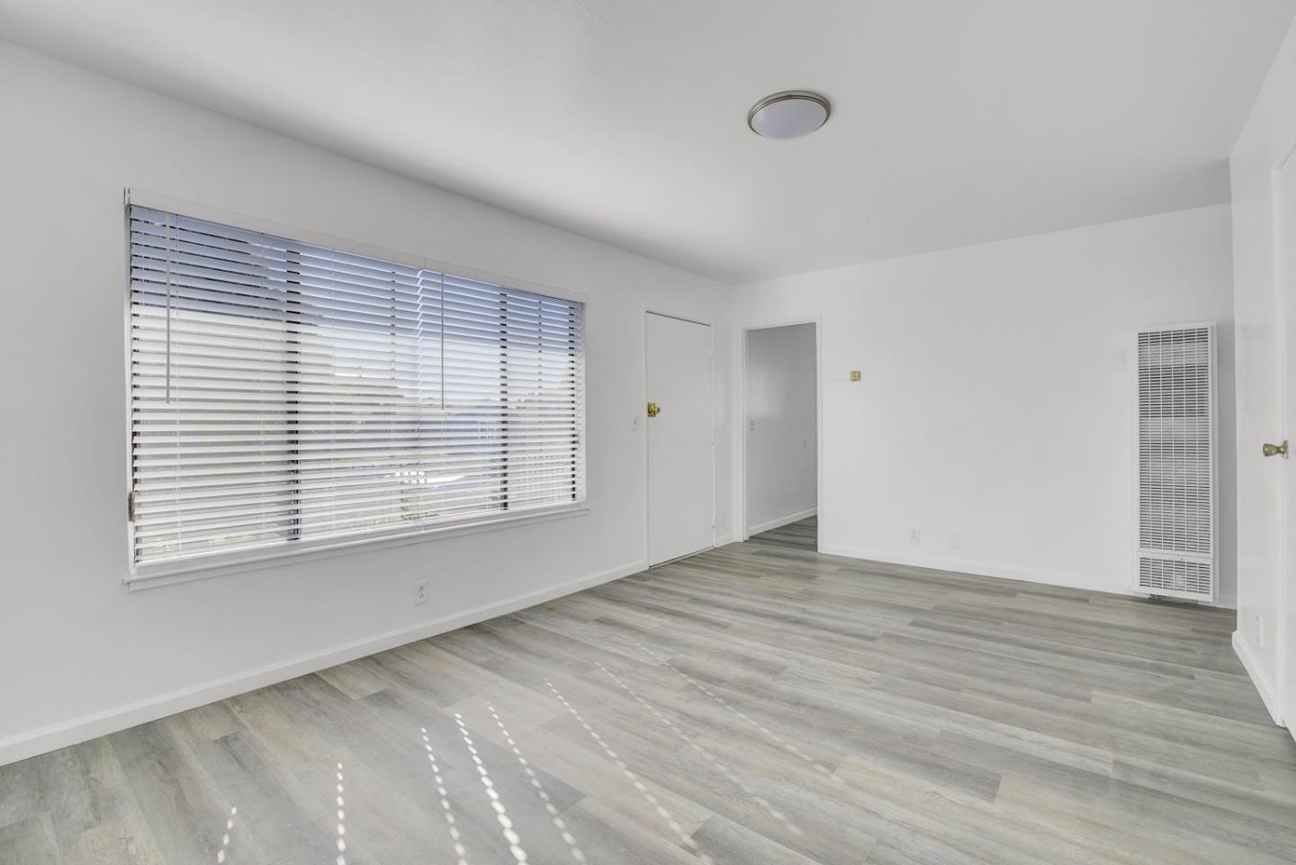 8811 A Street Oakland, CA 94621 - Photo 21 of 30 a view of an empty room with wooden floor and a window