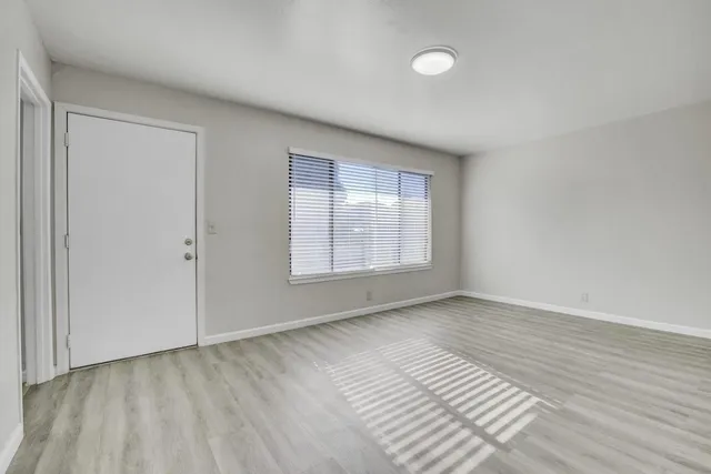 wooden floor in an empty room with a window