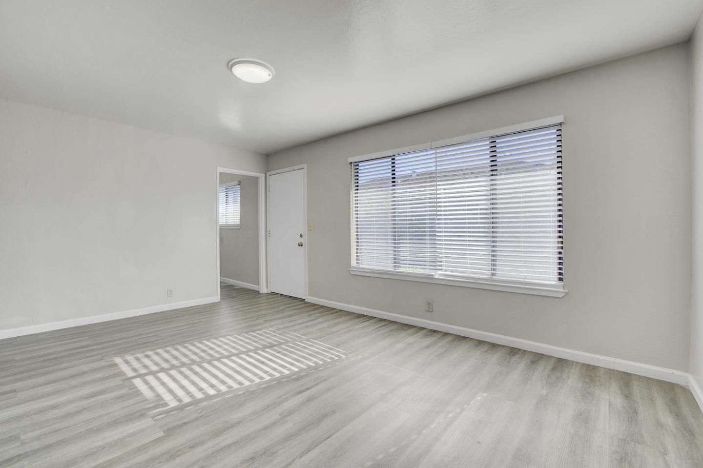 8811 A Street Oakland, CA 94621 - Photo 27 of 30 a view of an empty room with wooden floor and a window