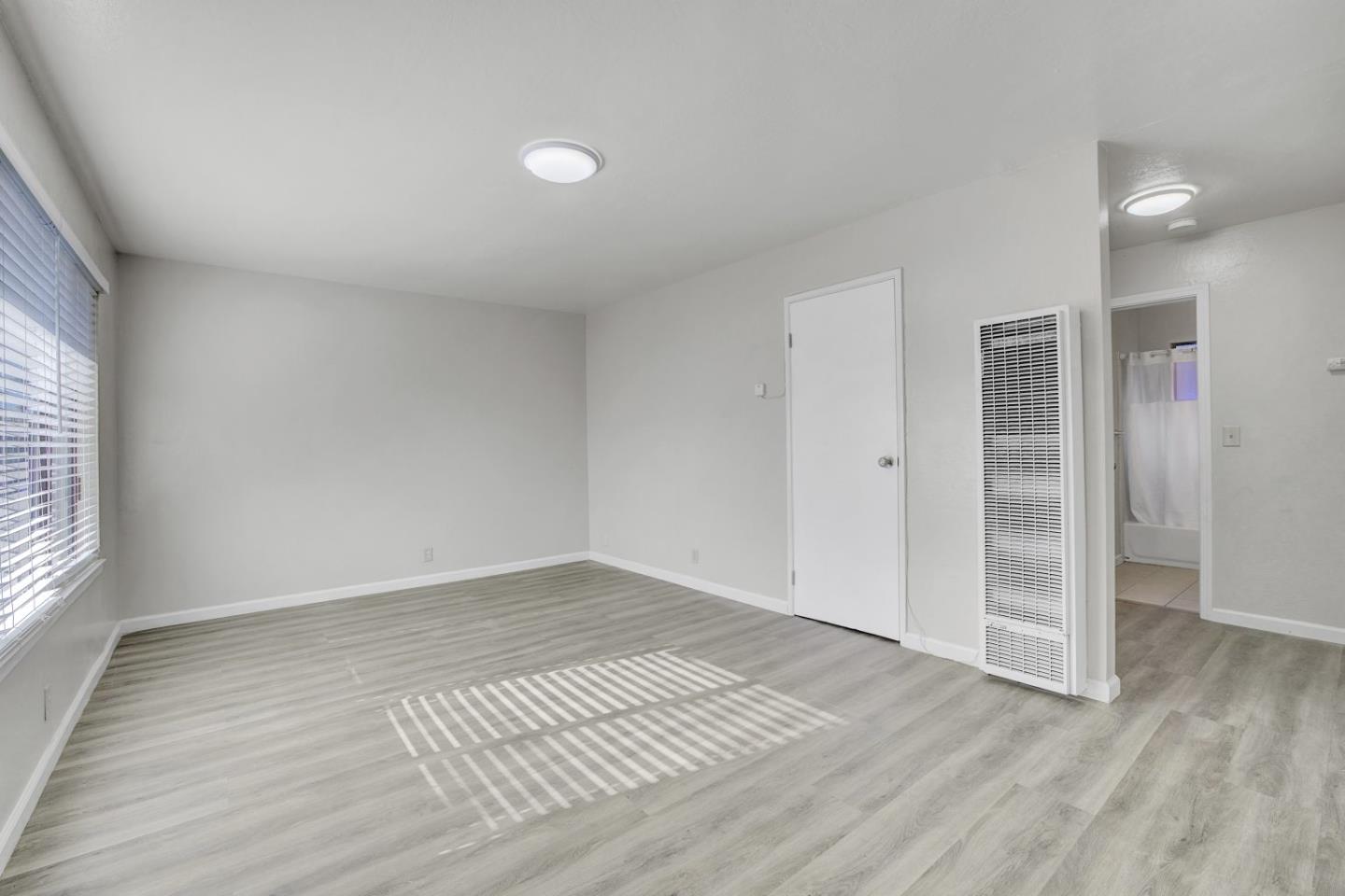 8811 A Street Oakland, CA 94621 - Photo 28 of 30 an empty room with wooden floor and windows