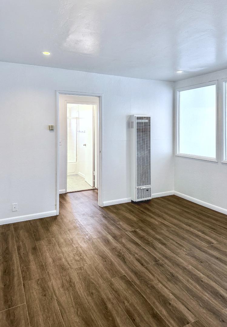 8811 A Street Oakland, CA 94621 - Photo 5 of 30 a view of an empty room with wooden floor and a window