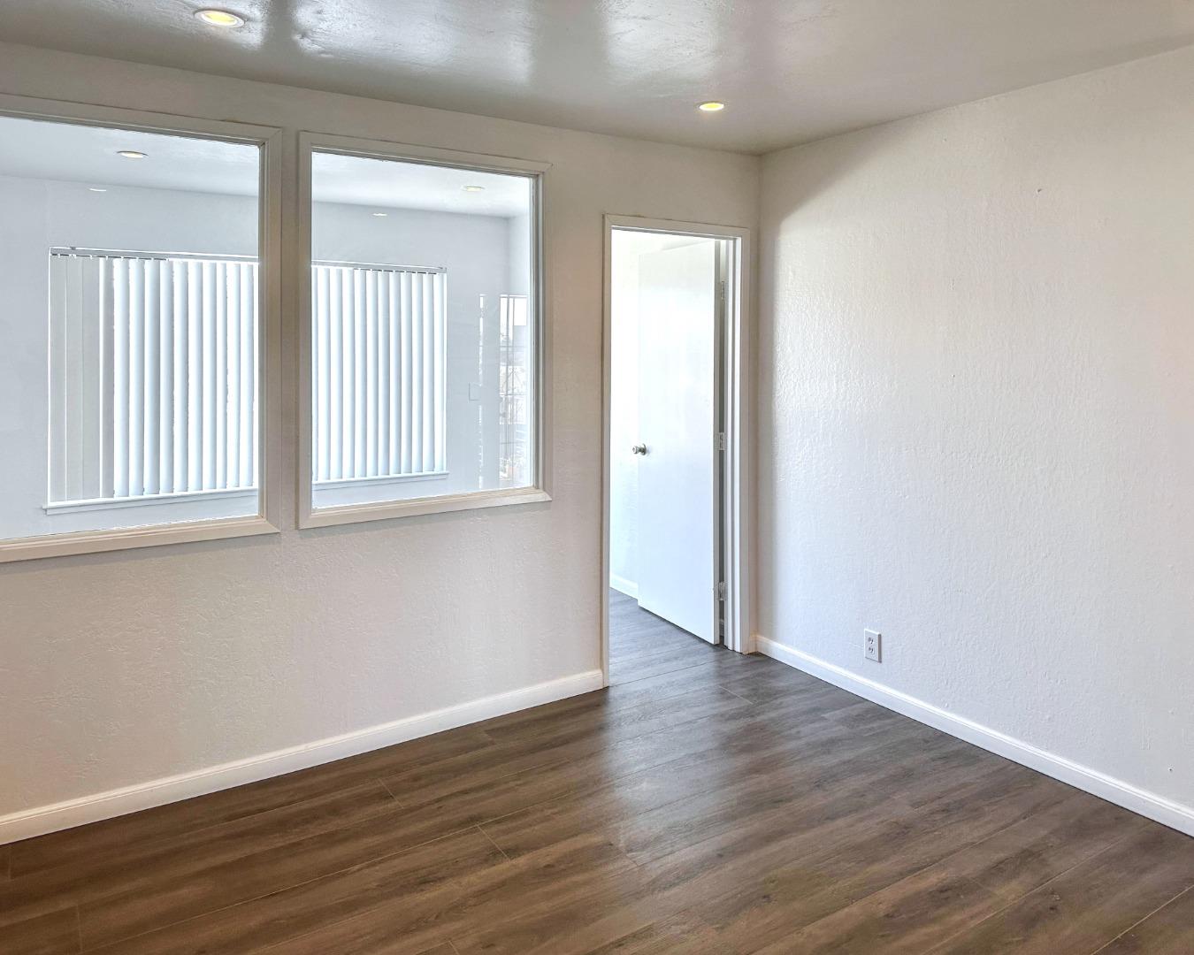 8811 A Street Oakland, CA 94621 - Photo 7 of 30 an empty room with wooden floor and windows
