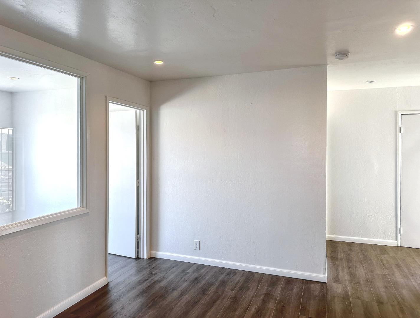8811 A Street Oakland, CA 94621 - Photo 9 of 30 an empty room with wooden floor and windows