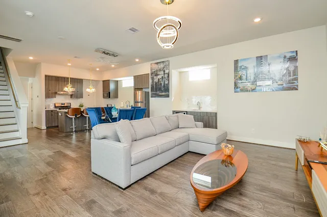 a living room with furniture and a view of kitchen