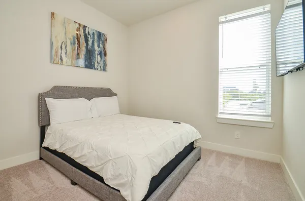 a large bed sitting in a bedroom next to a window