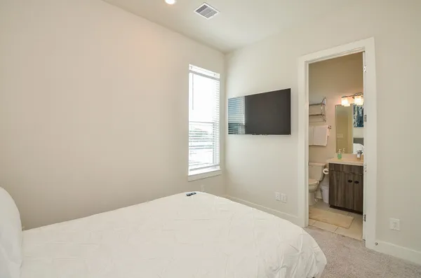 a bedroom with a bed and a flat screen tv