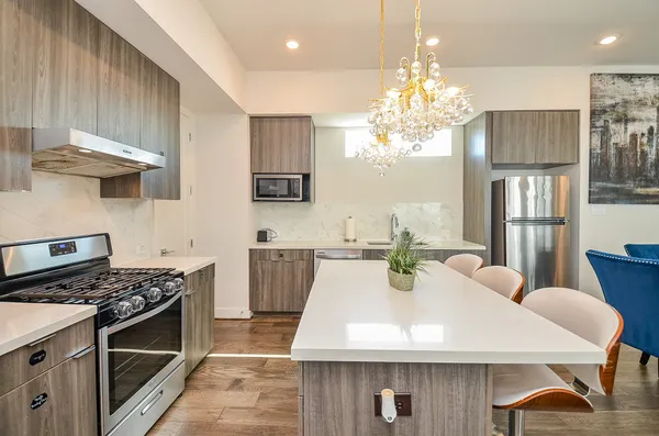 a kitchen with stainless steel appliances a table chairs and stove