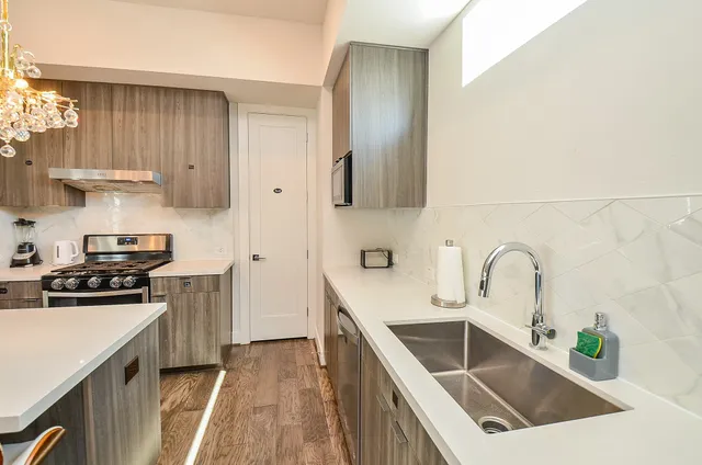 a kitchen with stainless steel appliances a sink stove and refrigerator