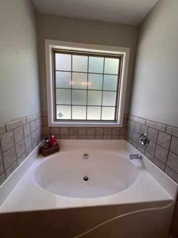 a white bath tub sitting in a bathroom next to a window