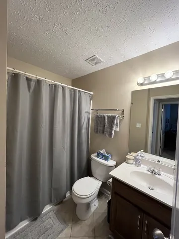 a bathroom with a sink a toilet a mirror and shower