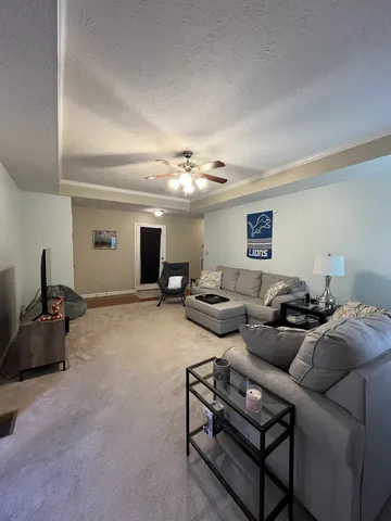 a living room with furniture and a chandelier