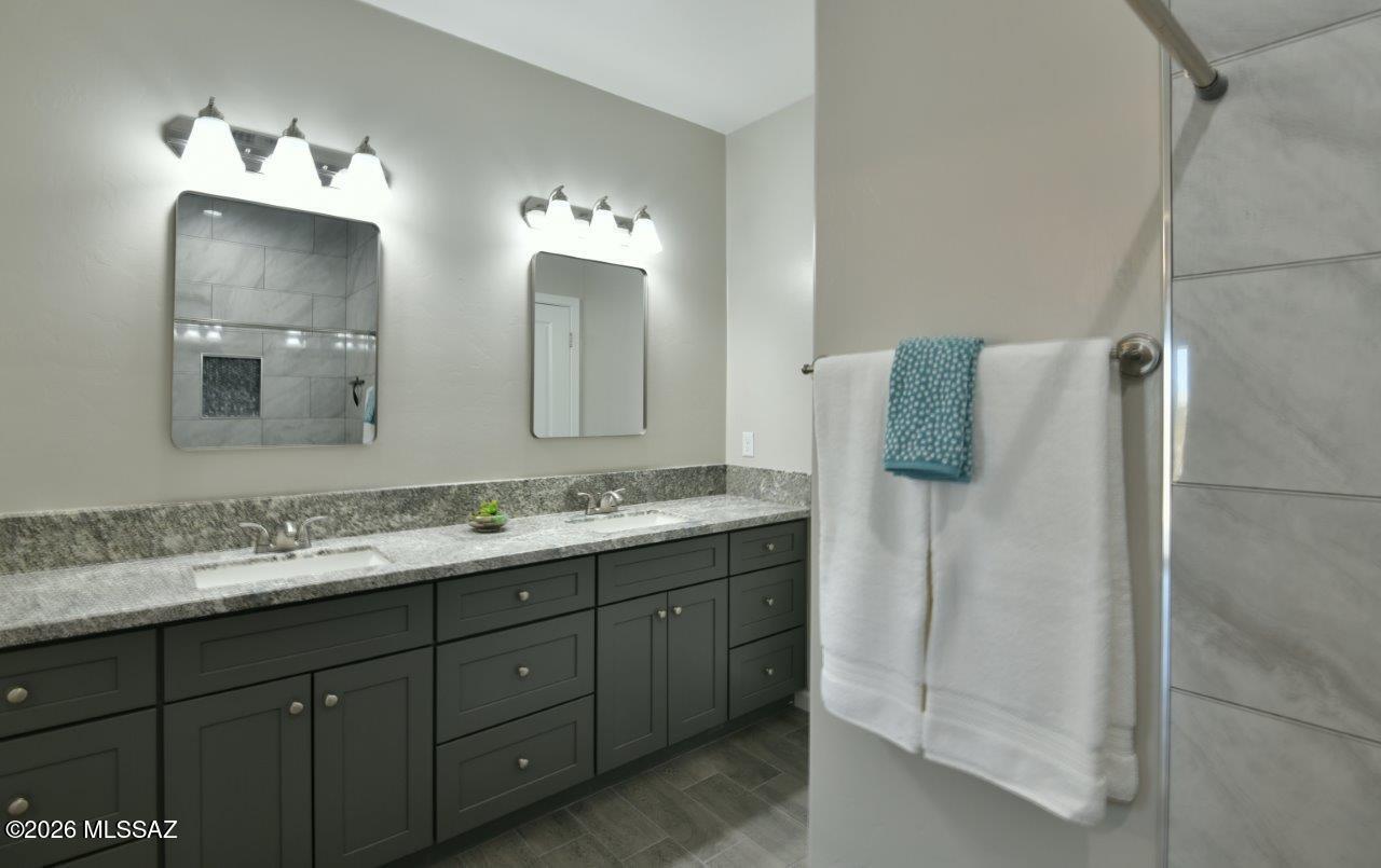 1091 North Vail View Road Vail, AZ 85641 - Photo 18 of 43 a bathroom with a double vanity sink and mirror