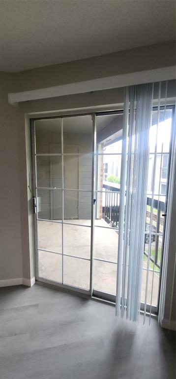 18333 Roehampton Drive, Unit 927 Dallas, TX 75252 - Photo 12 of 26 Empty room featuring plenty of natural light and wood finished floors