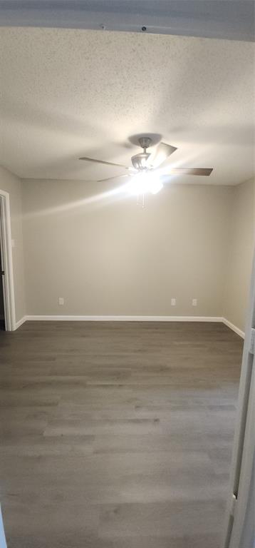 18333 Roehampton Drive, Unit 927 Dallas, TX 75252 - Photo 13 of 26 Unfurnished room featuring ceiling fan, a textured ceiling, and wood finished floors
