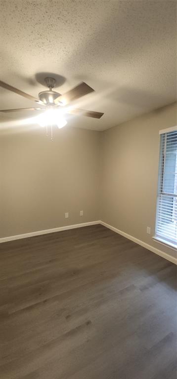 18333 Roehampton Drive, Unit 927 Dallas, TX 75252 - Photo 14 of 26 Spare room featuring a textured ceiling, dark wood-type flooring, and ceiling fan
