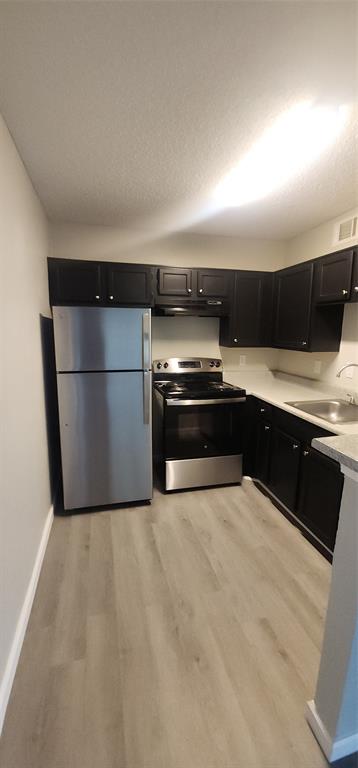 18333 Roehampton Drive, Unit 927 Dallas, TX 75252 - Photo 6 of 26 Kitchen with stainless steel electric range oven, refrigerator, dark cabinets, extractor fan, and light wood-type flooring