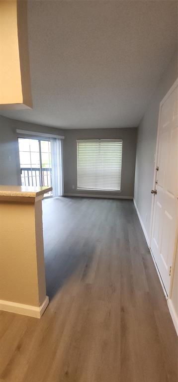 18333 Roehampton Drive, Unit 927 Dallas, TX 75252 - Photo 10 of 26 Unfurnished living room featuring wood finished floors