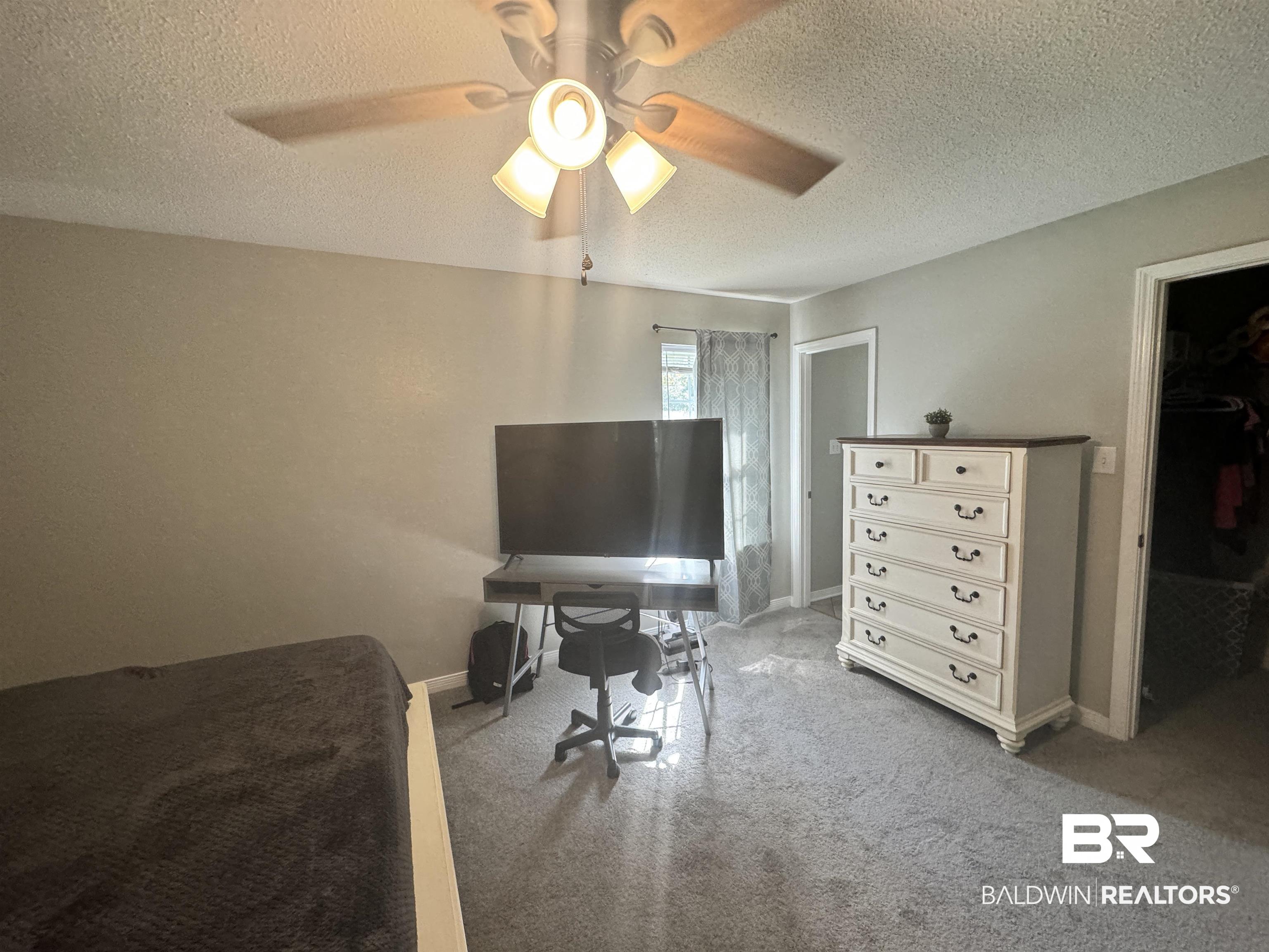 14313 Hemley Road Coden, AL 36523 - Photo 5 of 44 Carpeted bedroom with a closet, ceiling fan, a textured ceiling, and a walk in closet