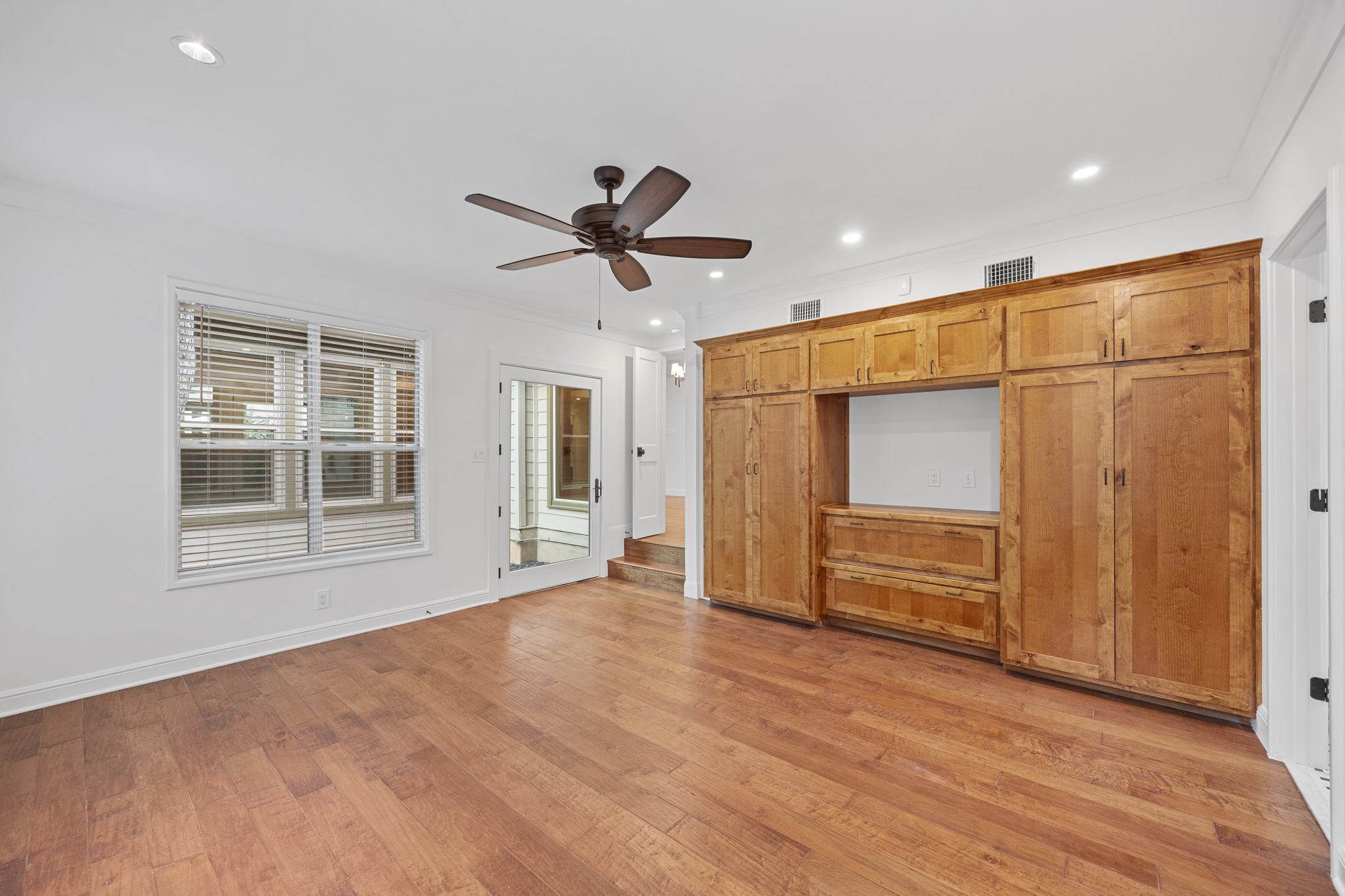 3205 Gilbert Street Austin, TX 78703 - Photo 11 of 35 Built-in wood cabinetry with central media niche, wood-finish flooring, recessed lighting, and ceiling fan
