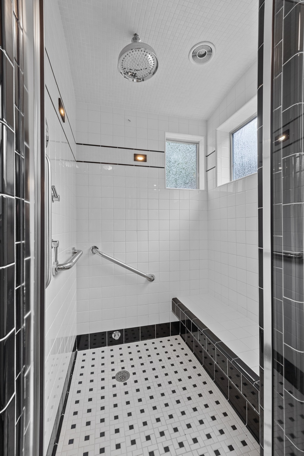 3205 Gilbert Street Austin, TX 78703 - Photo 13 of 35 Spacious shower with black and white tile design, including a built-in bench, dual grab bars, and two windows