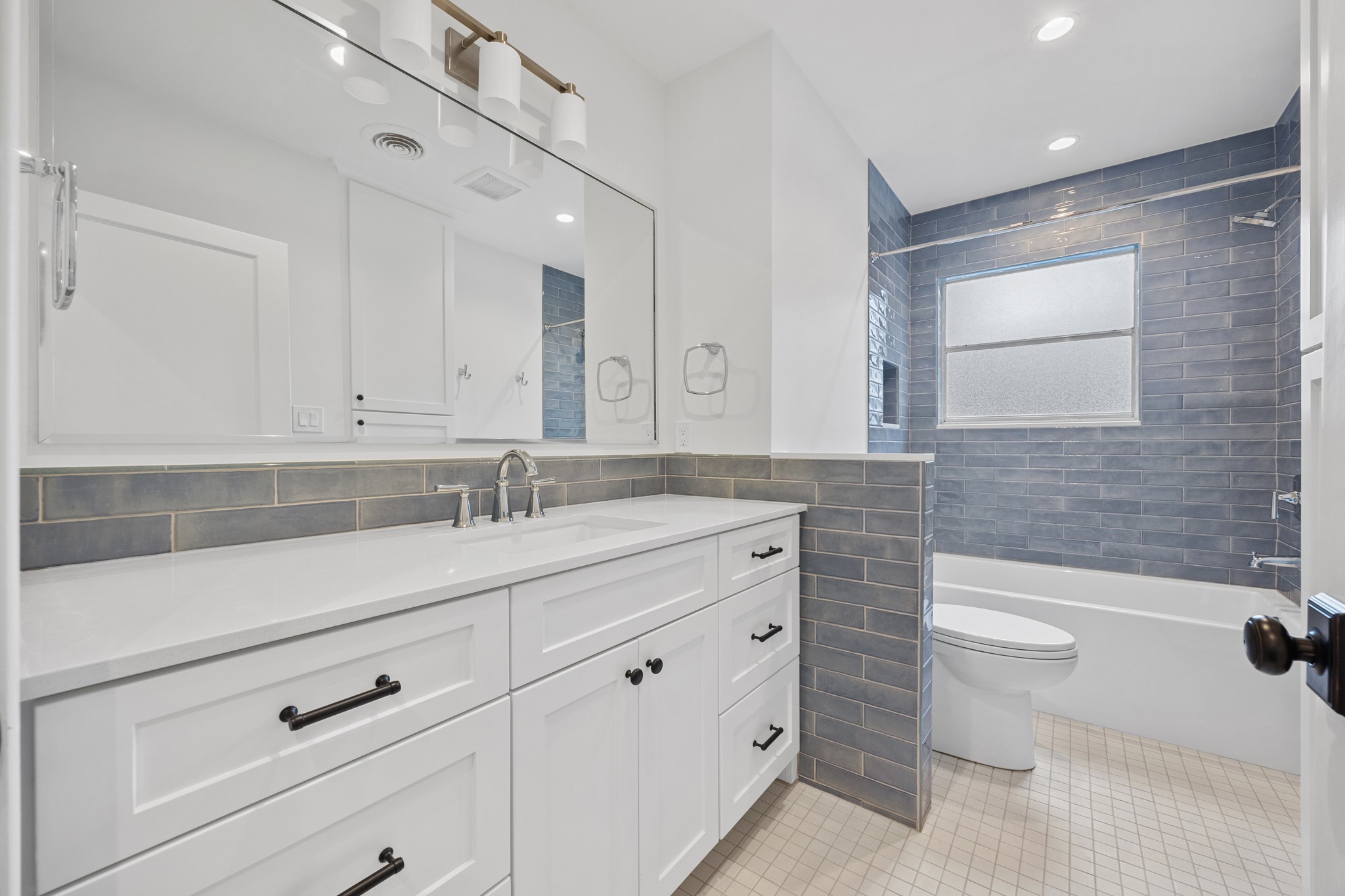 3205 Gilbert Street Austin, TX 78703 - Photo 21 of 35 Bathroom featuring a white vanity with an integrated sink and brushed nickel faucet, large mirror, and recessed lighting